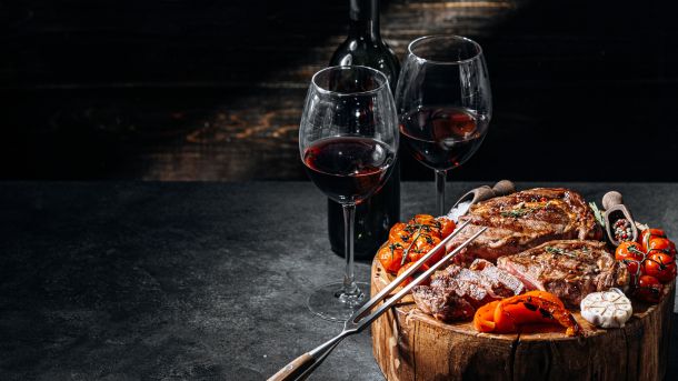 grilled steak with tomatoes and wine glasses - Houston Steak Night